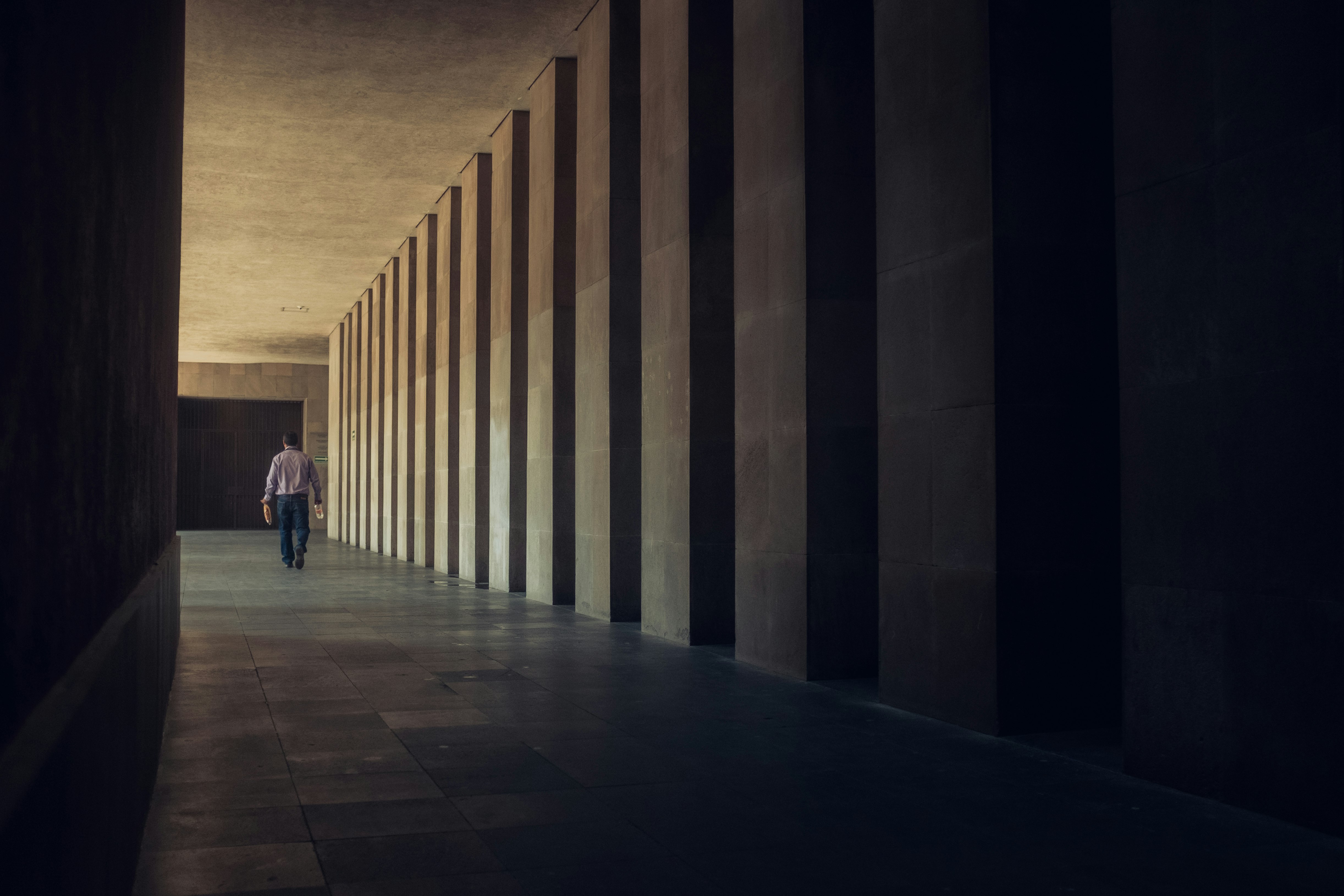 man in black jacket walking on hallway